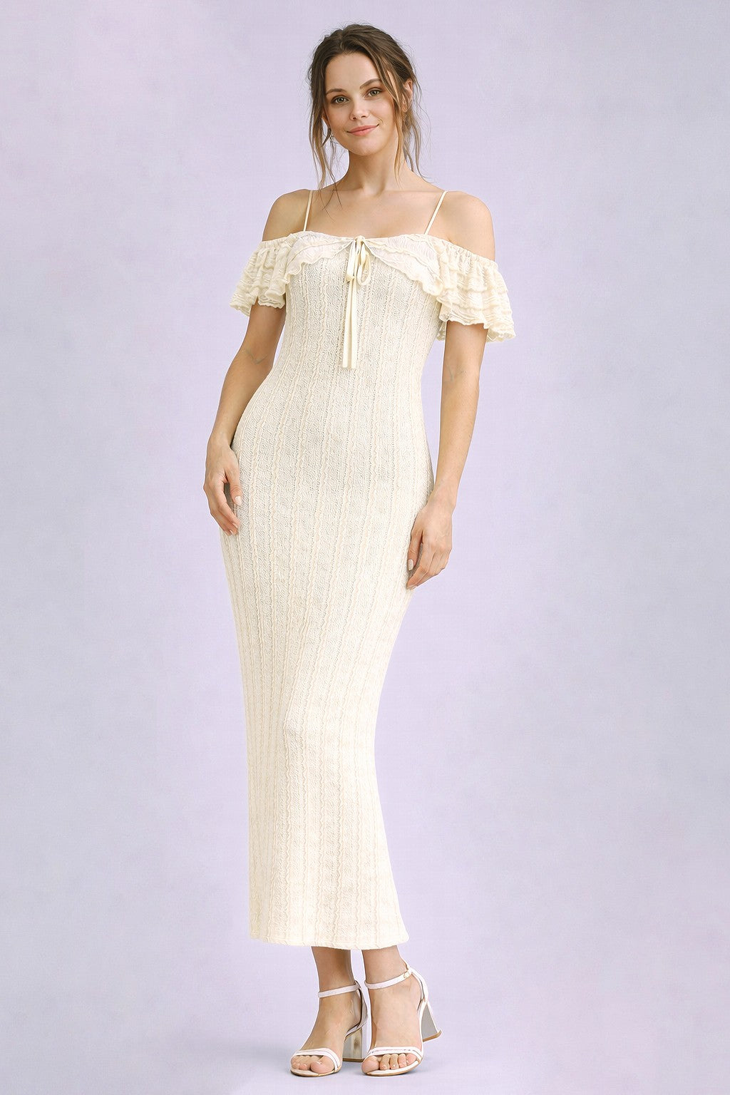 woman wearing a cream off-the-shoulder maxi dress with ruffle sleeves and a tie detail, standing against a soft background