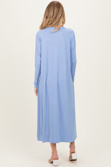 woman wearing a light blue long sleeve maternity maxi dress, shown from the back with a flowing silhouette