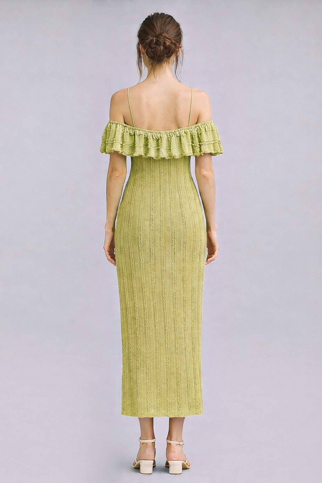 woman wearing a light green off-the-shoulder ribbed midi dress with ruffled hem and fitted silhouette