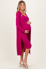woman wearing a fuchsia maternity dress with a matching long cardigan and holding her baby bump