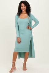 woman wearing a mint green ribbed midi dress with a matching long cardigan, styled with strappy heels