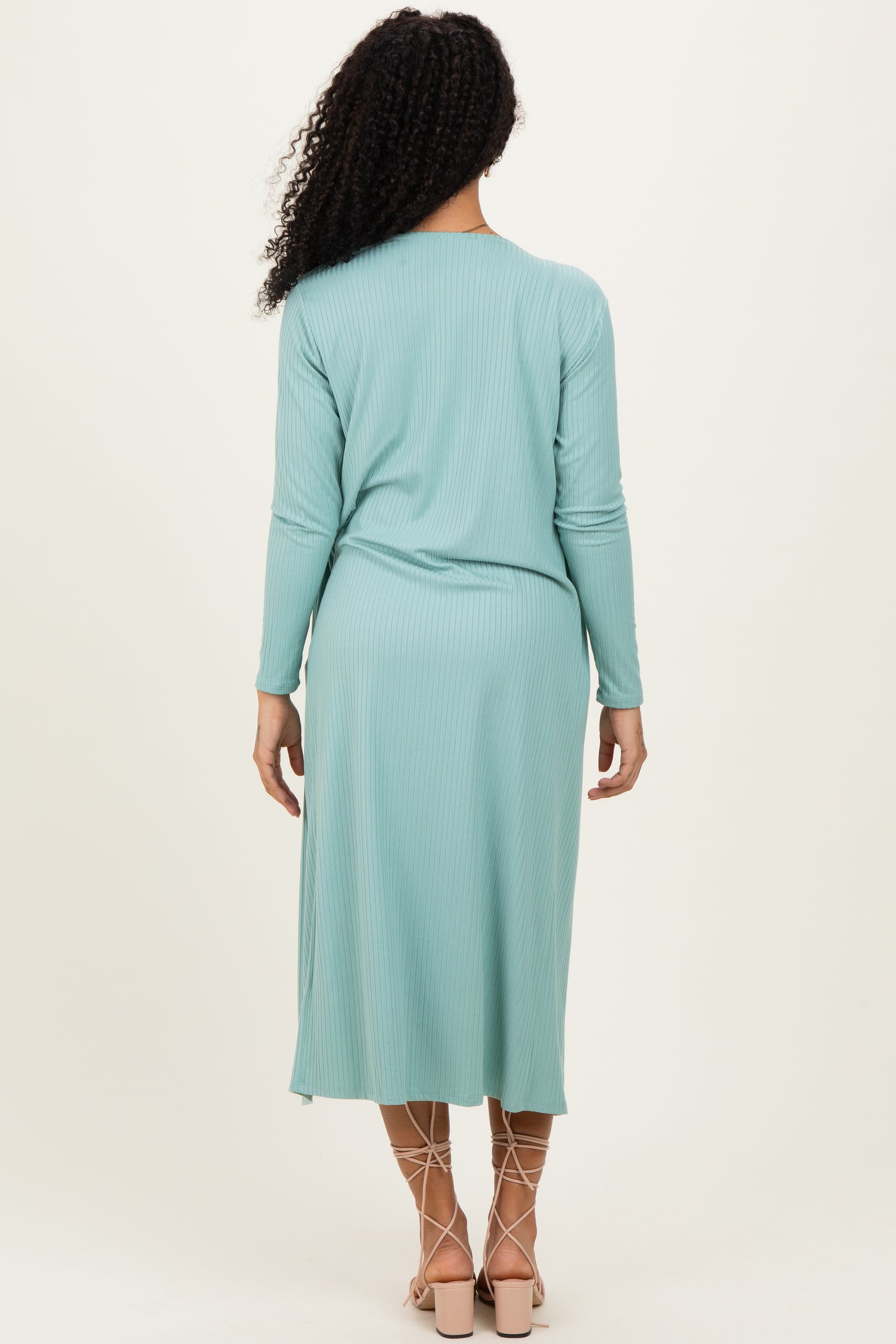woman wearing a mint green ribbed long sleeve midi dress with a relaxed fit and back pleat detail