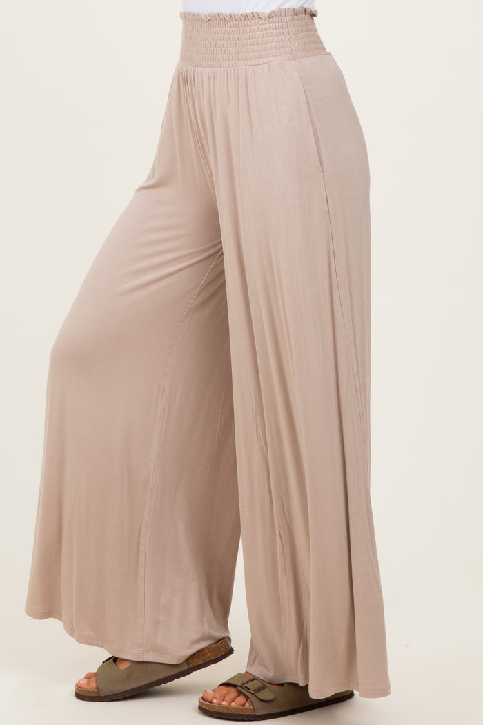 woman wearing light beige wide-leg pants with an elastic waistband and a relaxed fit