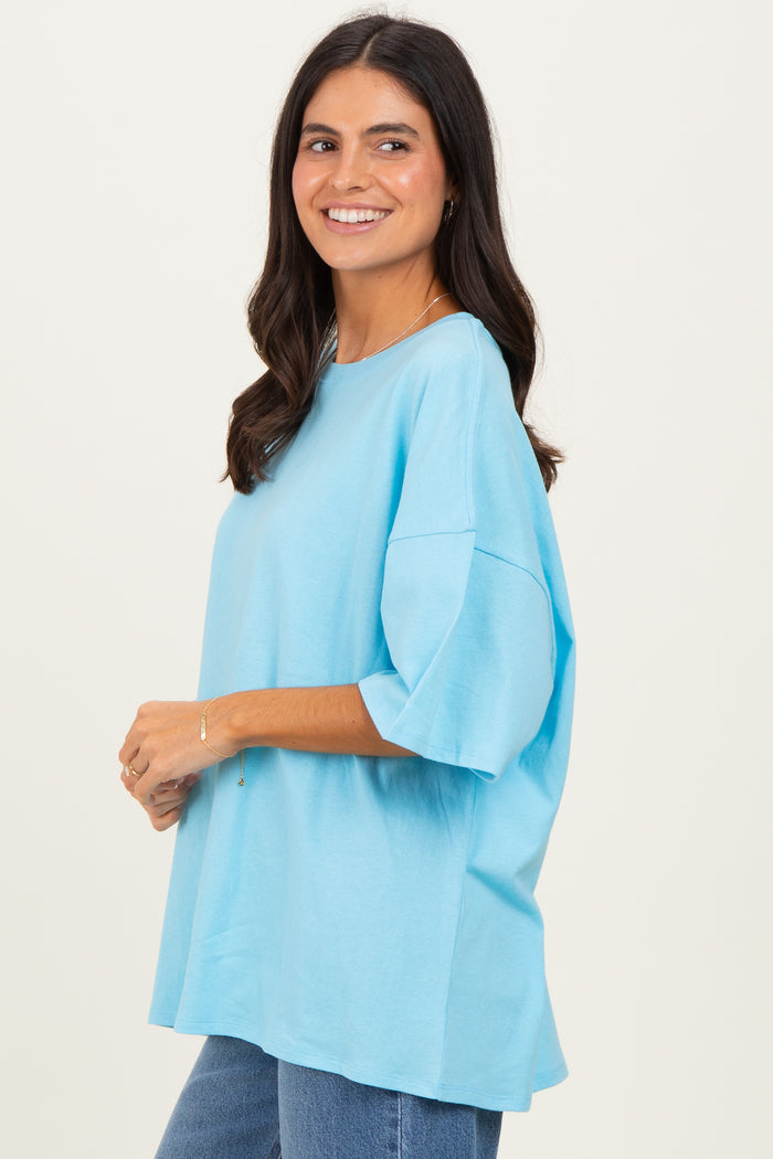 woman wearing a light blue oversized t-shirt with short sleeves and a relaxed fit