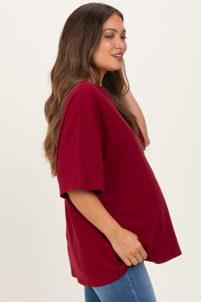 woman wearing a burgundy oversized maternity t-shirt with short sleeves and a visible baby bump