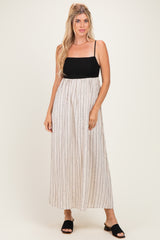 woman wearing a black and white striped maxi dress with spaghetti straps and a fitted bodice