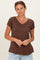 woman wearing a brown v-neck short sleeve top with a relaxed fit and light blue jeans