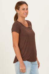 woman wearing a brown short sleeve v-neck top and light blue jeans