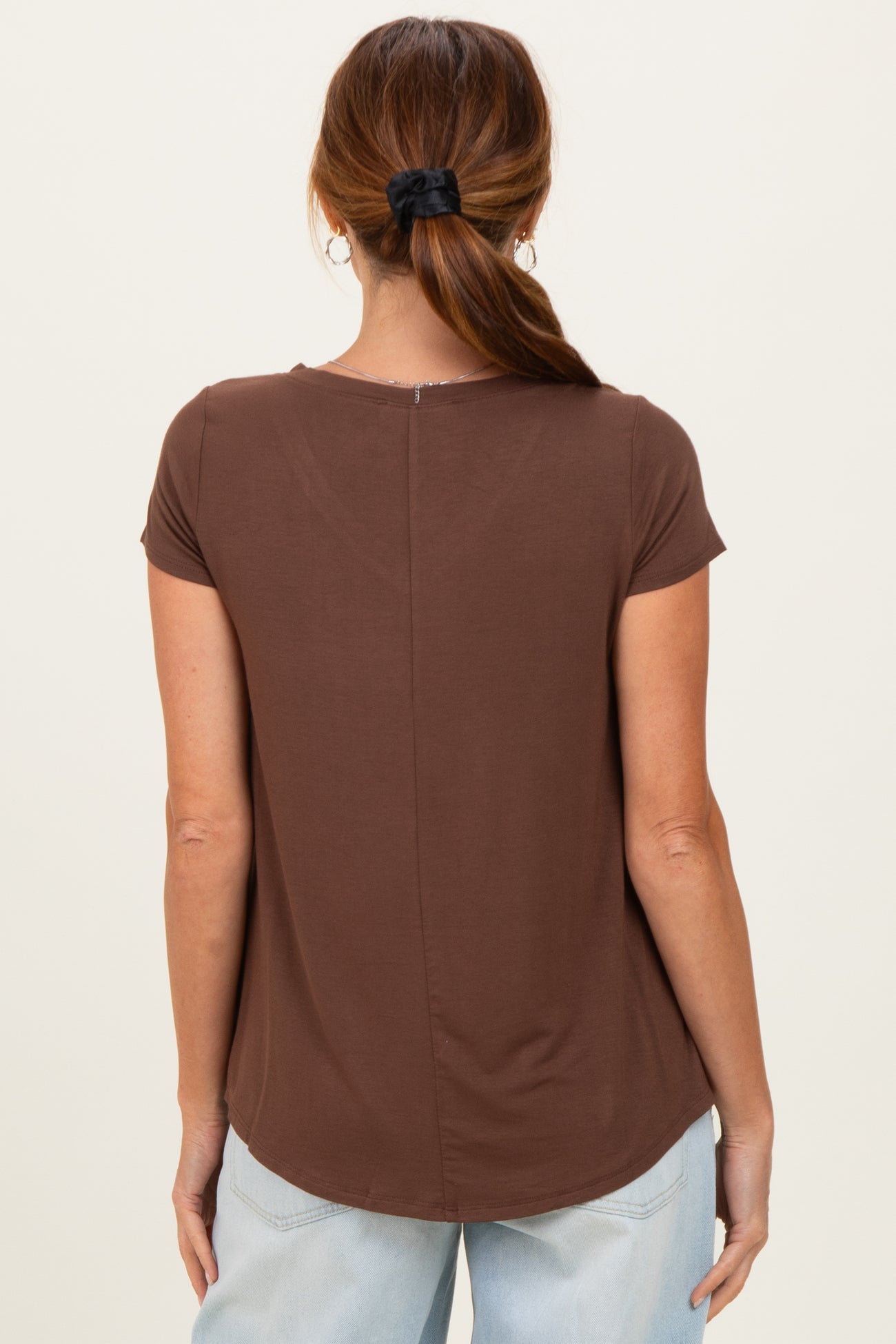 woman wearing a brown short sleeve t-shirt with a relaxed fit and a back seam detail