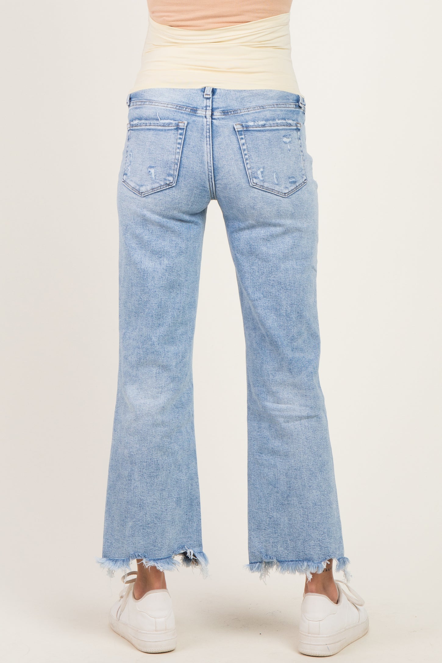 maternity wear light blue distressed wide leg jeans with frayed hem, model seen from the back