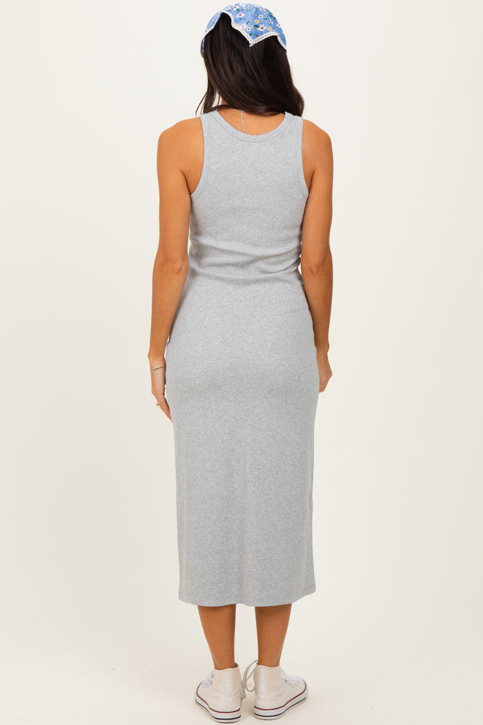 woman wearing a grey sleeveless midi dress, viewed from the back, with a blue patterned headband and casual sneakers