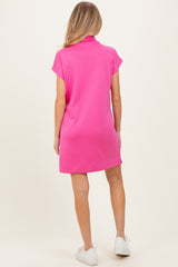 woman wearing a bright pink maternity dress with short sleeves and a relaxed fit, viewed from the back