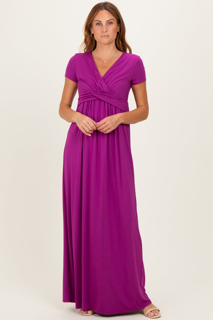 woman wearing a purple short sleeve maxi dress with a wrapped bodice and flowy skirt