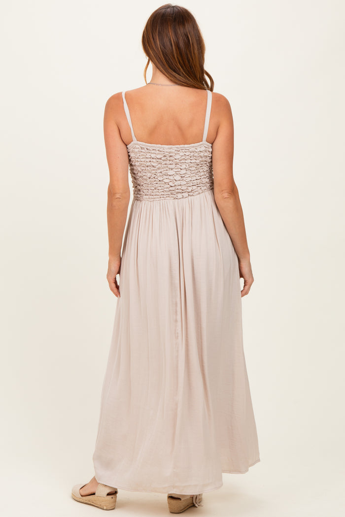 woman wearing a light beige maxi dress with a smocked bodice and spaghetti straps, seen from the back
