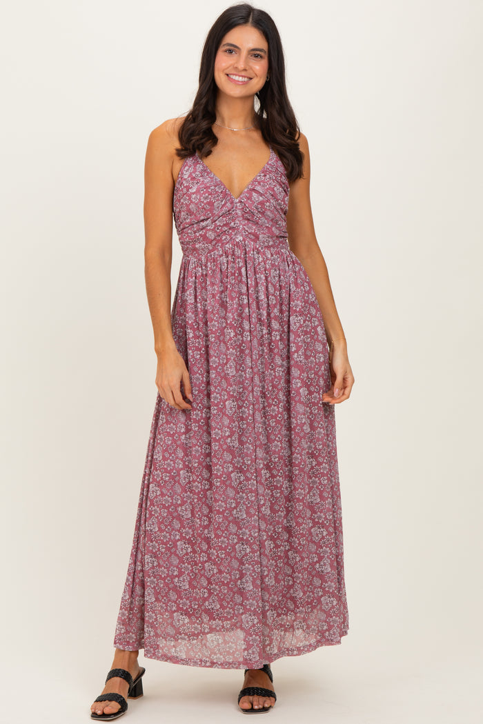 woman wearing a burgundy floral maxi dress with a fitted bodice and flowy skirt