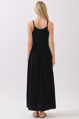 woman wearing a black sleeveless maxi dress with a smocked back and a flowy skirt
