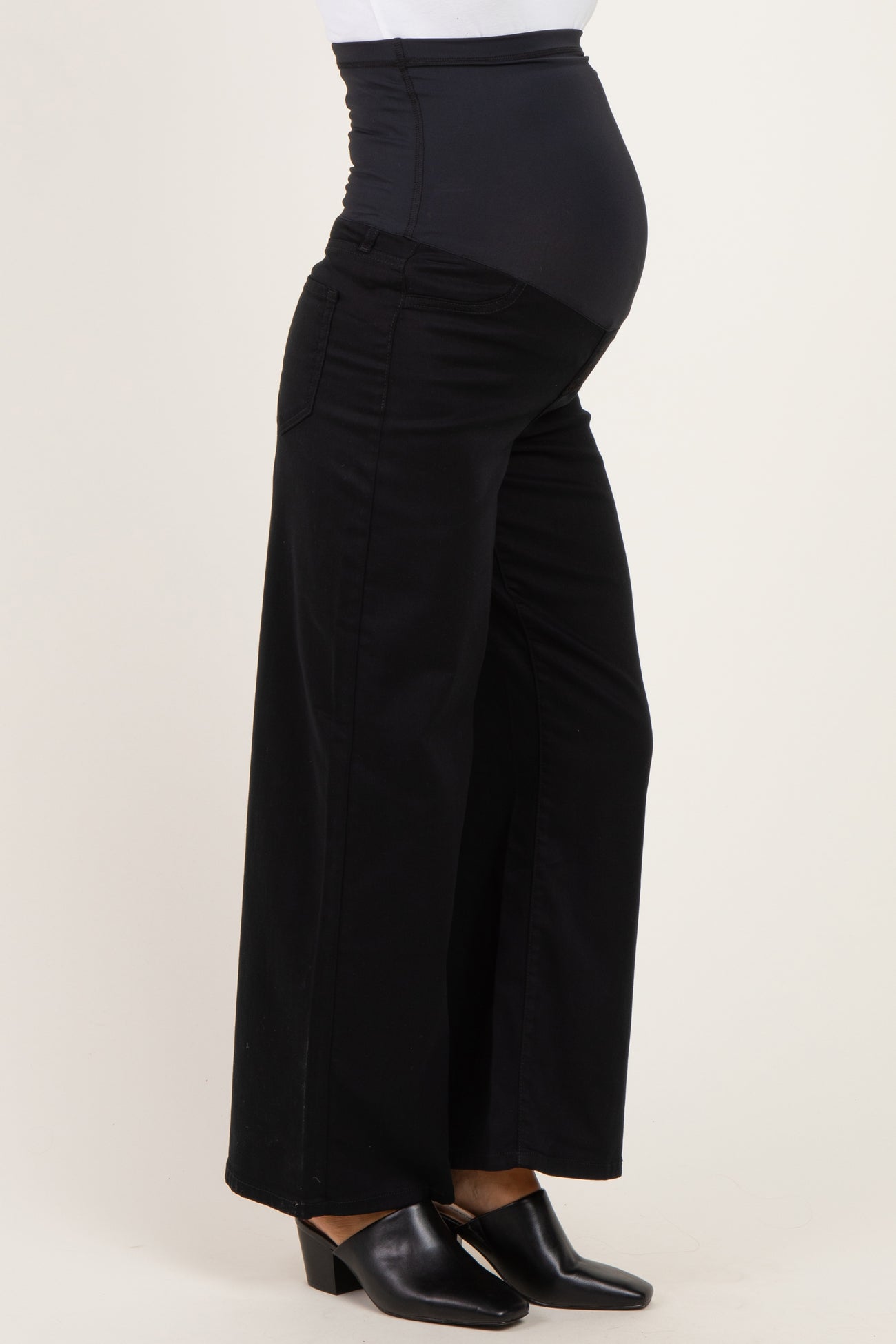 woman wearing black maternity trousers with a stretchy over-the-bump waistband and a visible baby bump