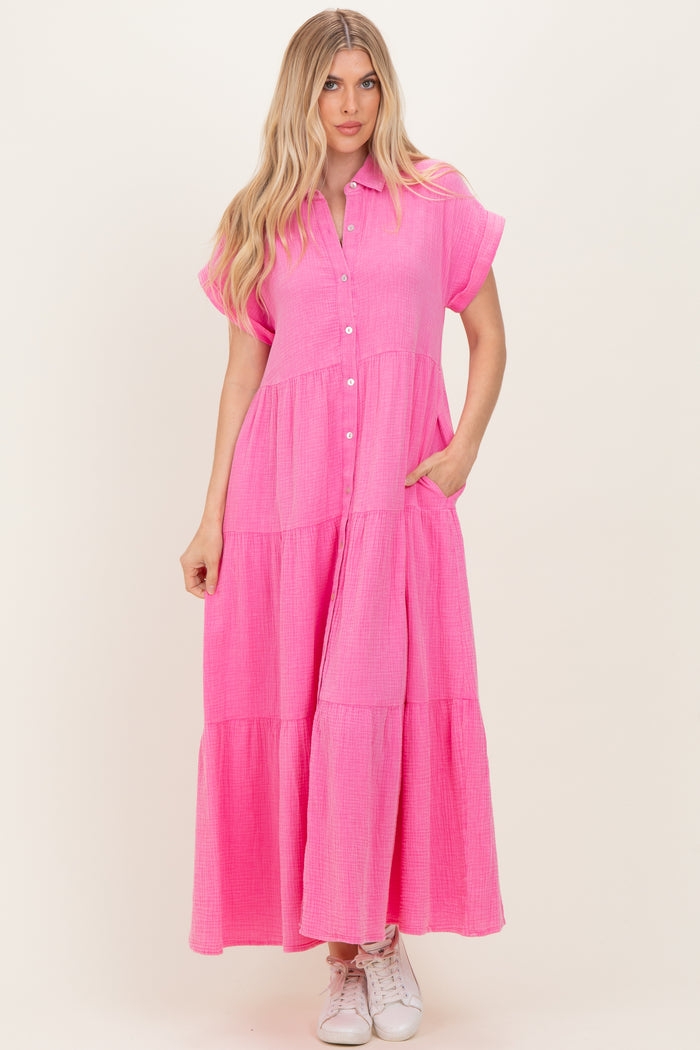 woman wearing a bright pink button-up maxi dress with short sleeves and tiered skirt detail