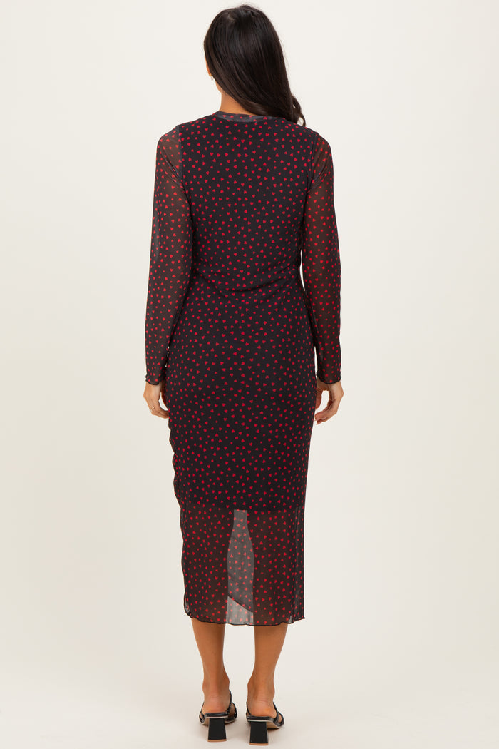 woman wearing a long sleeve navy blue midi dress with red polka dots, seen from the back