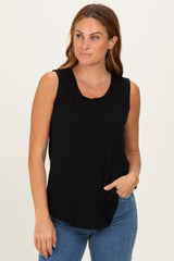 woman wearing a black sleeveless top with a scoop neckline and a relaxed fit, paired with blue jeans