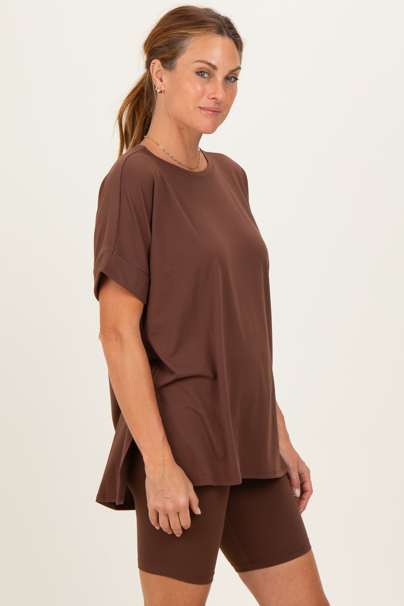 woman wearing a brown oversized short sleeve top and matching bike shorts