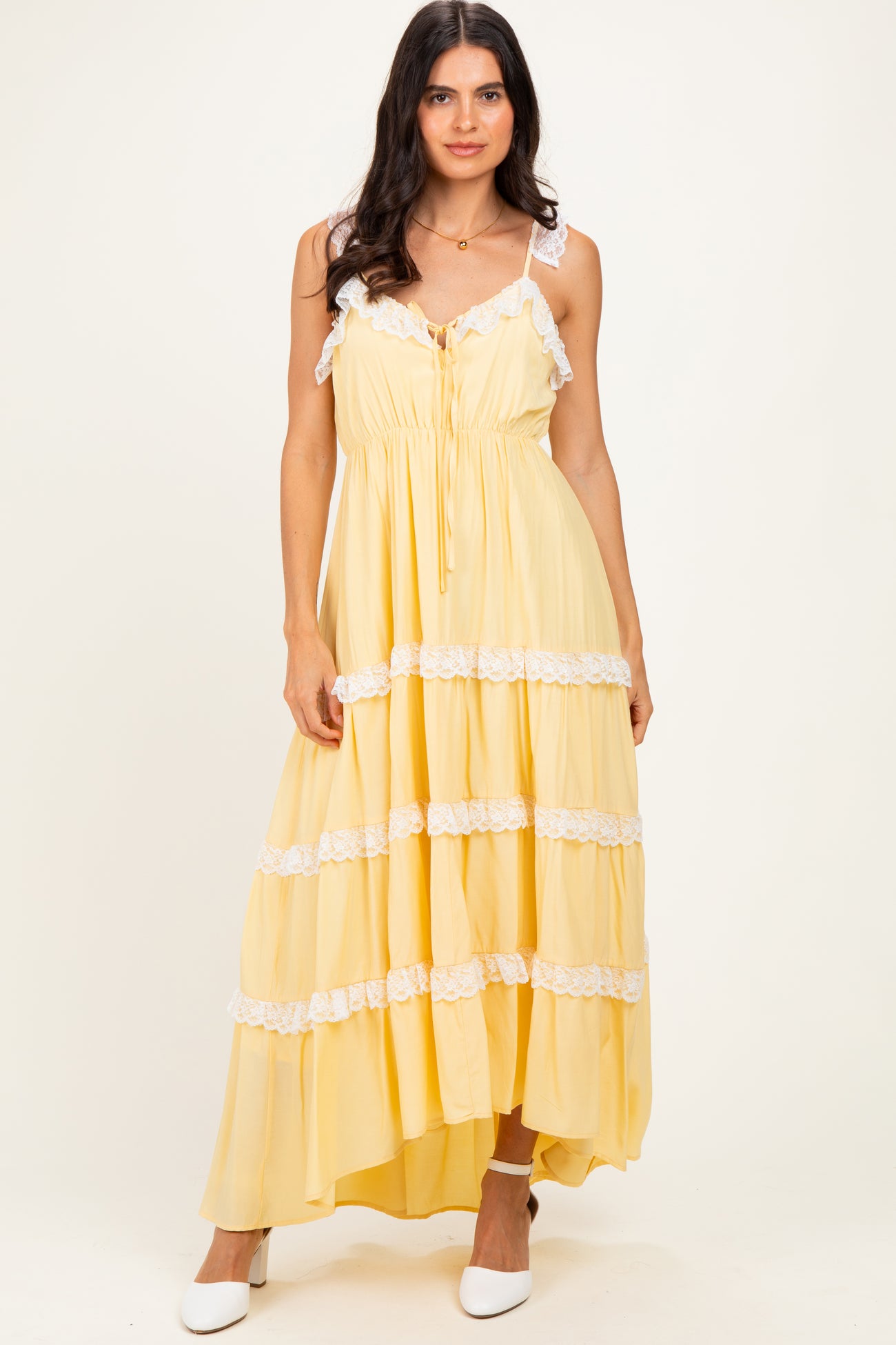 woman wearing a yellow tiered maxi dress with lace trim and adjustable straps