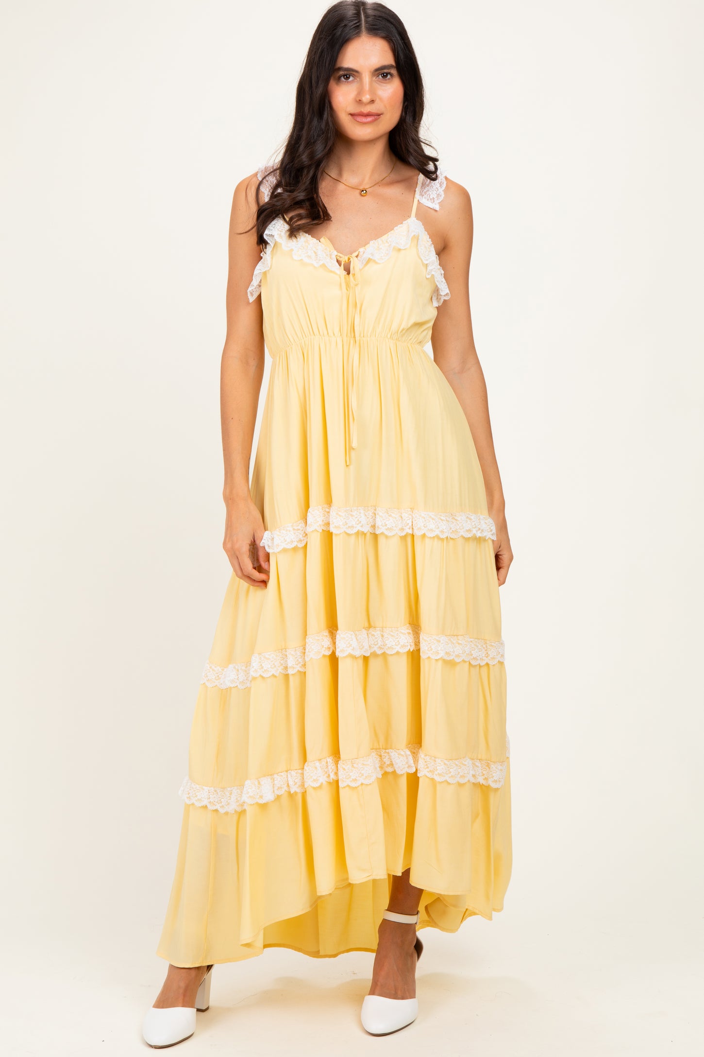 woman wearing a yellow tiered maxi dress with lace trim and adjustable straps