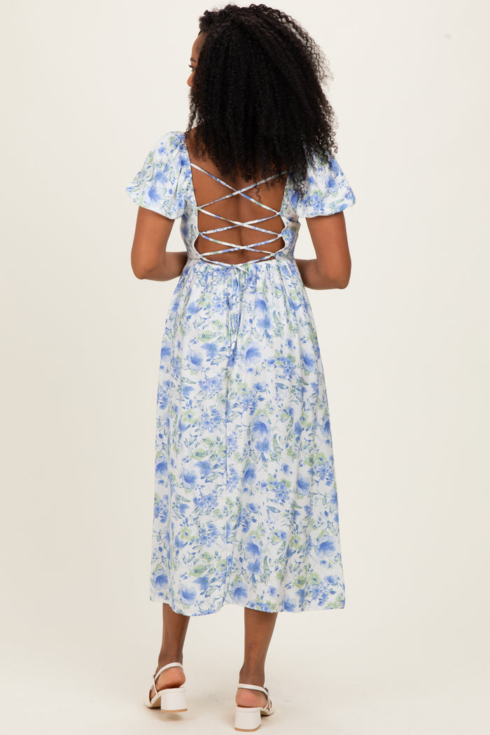 woman wearing a blue floral midi dress with a lace-up back and short puff sleeves