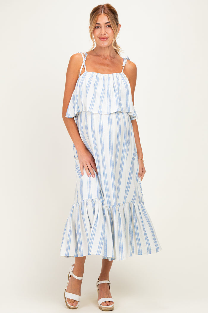 woman wearing a white and blue striped maternity dress with a layered ruffle detail and a flowy hem, showcasing her baby bump