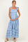 woman wearing a blue and white striped maternity maxi dress with tie straps and holding her baby bump