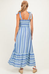 woman wearing a blue and white striped maternity maxi dress with tie straps and a tiered hem