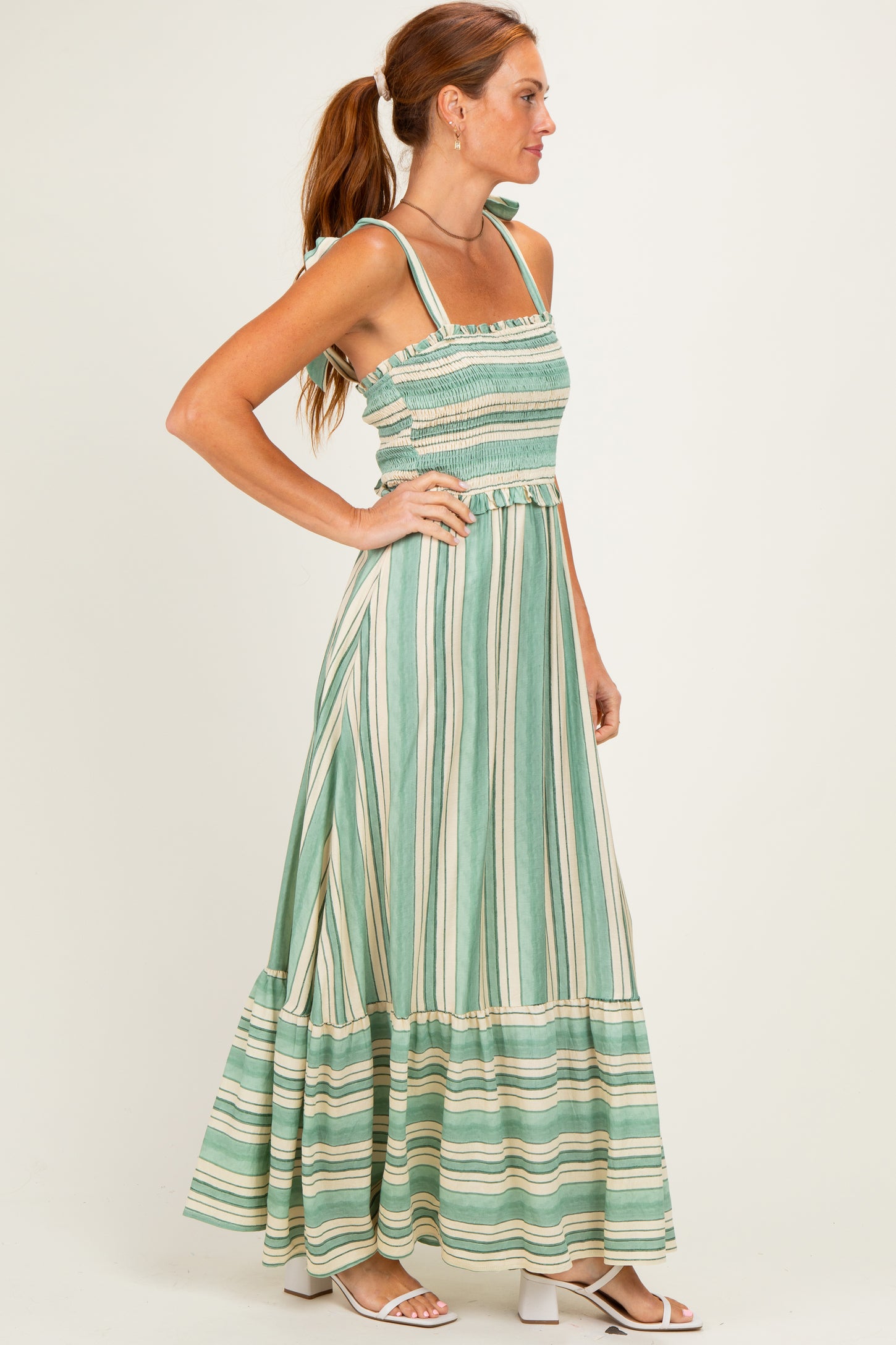 woman wearing a green and white striped maxi dress with smocked bodice and tiered skirt