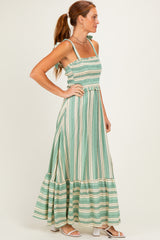 woman wearing a green and white striped maxi dress with smocked bodice and tiered skirt