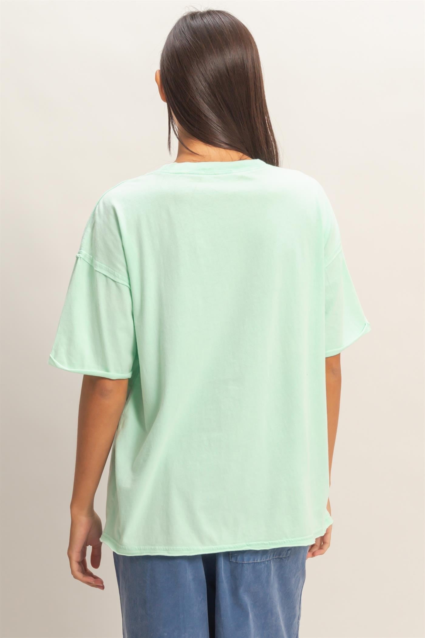 woman wearing a mint green oversized t-shirt with a relaxed fit and short sleeves