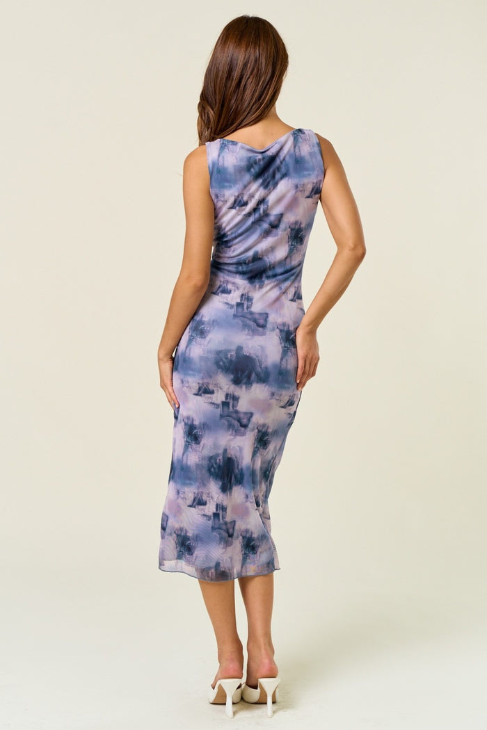 woman wearing a sleeveless purple and blue watercolor print midi dress, showing the back view