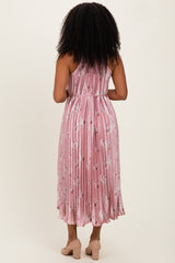 woman wearing a pink pleated midi dress with floral print, shown from the back