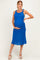 woman wearing a bright blue knitted maternity dress with tie straps and a visible baby bump