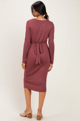 woman wearing a mauve long sleeve midi dress with a tie waist detail, shown from the back