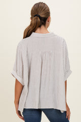 woman wearing a beige and white striped short sleeve blouse with a relaxed fit and back yoke detail