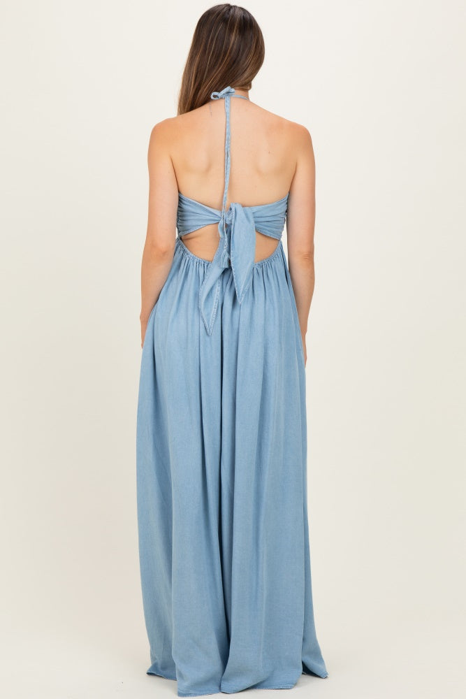 woman wearing a chambray long maternity dress with a halter neck and open back, revealing a baby bump