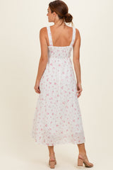 woman wearing a white floral midi dress with adjustable straps and a smocked back, shown from the back