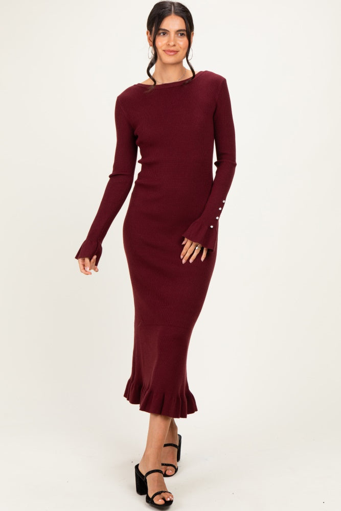 woman wearing a burgundy ribbed long sleeve midi dress with flared hem and button details on the sleeves