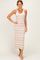woman wearing a tan and white striped maxi dress with a fitted silhouette and spaghetti straps