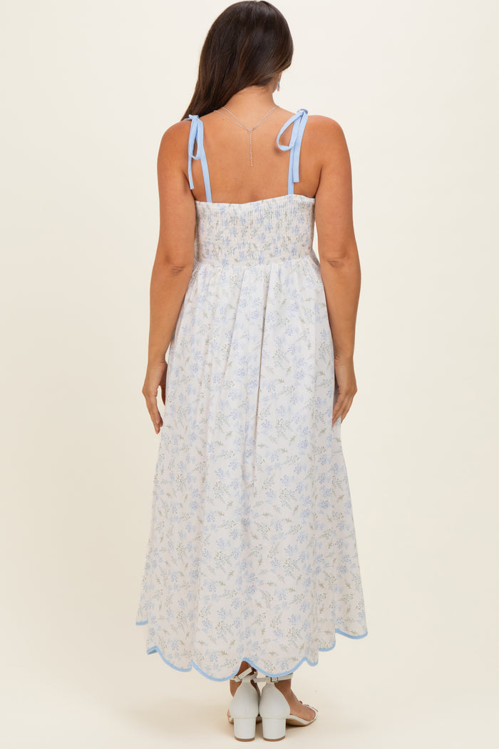 woman wearing a light blue floral maternity maxi dress with smocked back and tie shoulder straps