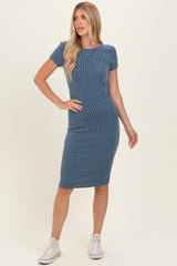 woman wearing a blue ribbed short sleeve dress with a fitted silhouette and white sneakers