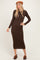 woman wearing a brown long sleeve ribbed midi dress and a brown beret, standing confidently with one hand on her hip