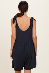 woman wearing a navy blue sleeveless romper with tie straps and a relaxed fit from the back