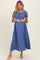 woman wearing a blue maternity dress with puff sleeves and a smocked bodice, showing her baby bump