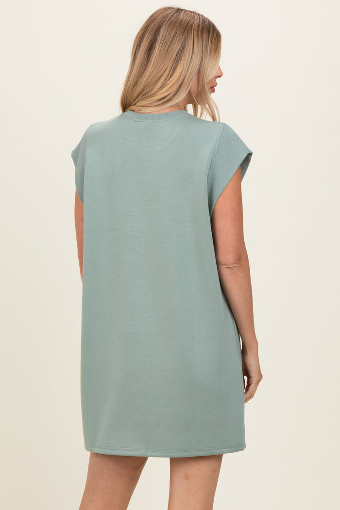 woman wearing a green oversized t-shirt dress with short sleeves, shown from the back