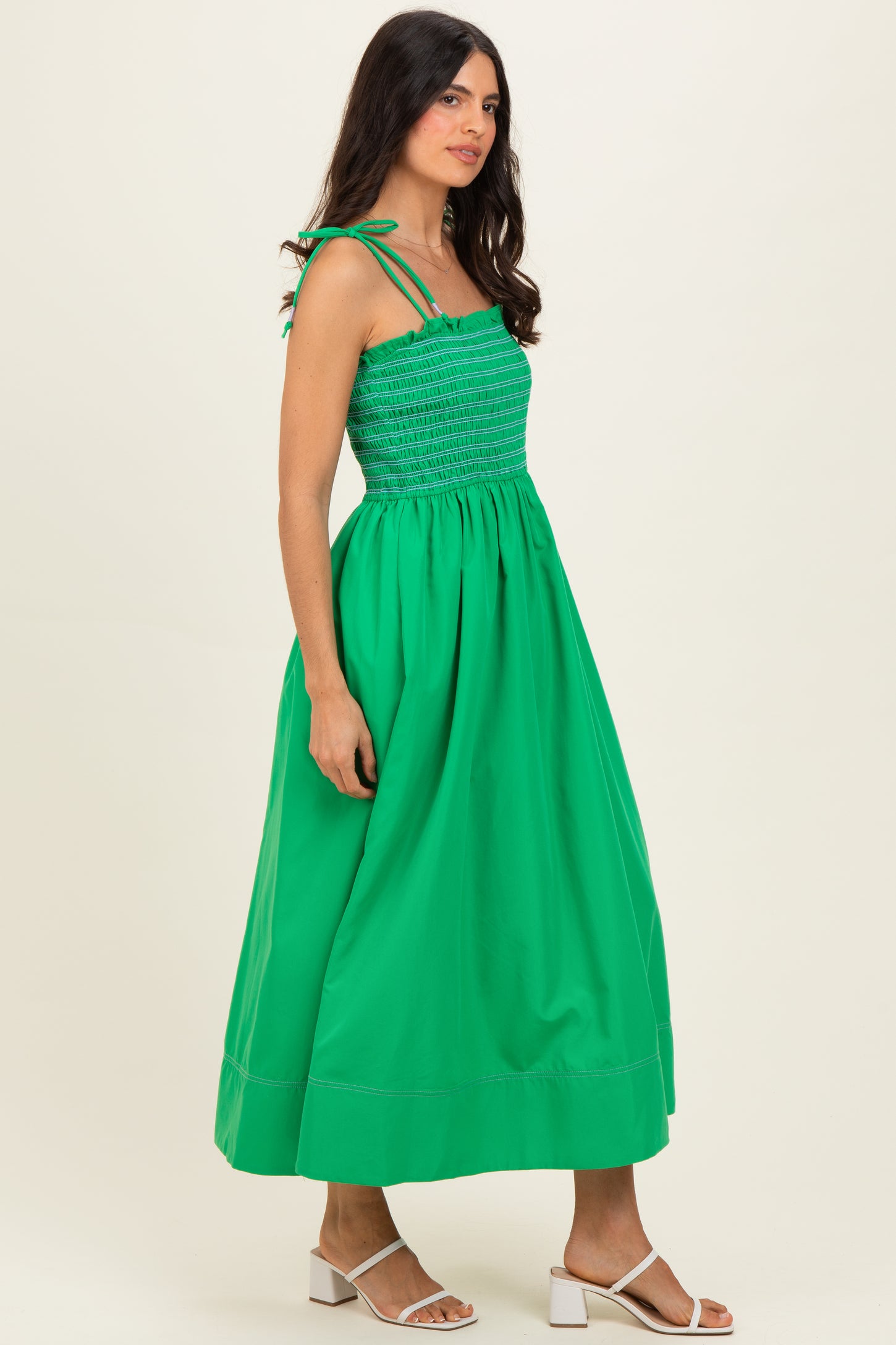 woman wearing a vibrant green maxi dress with smocked bodice and adjustable straps